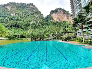 a large swimming pool with mountains in the background at IPOH All Suite Resort, Jalan Haven, Persiaran Lembah Perpaduan, Ipoh Perak in Ipoh