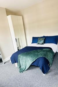 a bedroom with a bed with blue and green sheets at Spacious home near CityCentre Parking/Wifi/Netflix in Nottingham