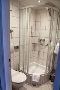 a bathroom with a shower and a toilet at Hotel Alpha in Stuttgart