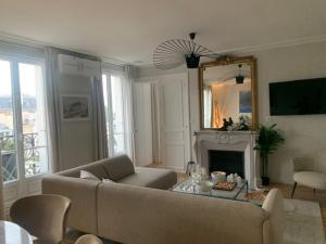 een woonkamer met een bank en een open haard bij Le Ciel de Paris - Montparnasse & Jardin du Luxembourg in Parijs