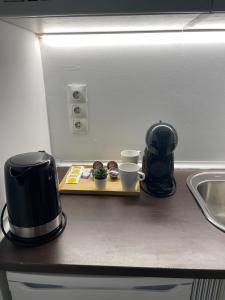 a coffee maker and two cups on a kitchen counter at C2 Exclusiva zona Madrid in Madrid