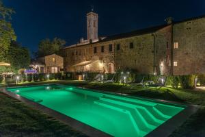 a swimming pool in front of a building at night at Convento San Bartolomeo - Piscina Esterna Riscaldata in Abbadia San Salvatore