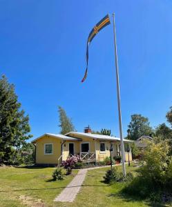 um mastro de bandeira em frente a uma casa em Gula huset em Jomala