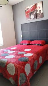casa green con club de alberca في تيبيك: غرفة نوم بسرير احمر مع لحاف احمر