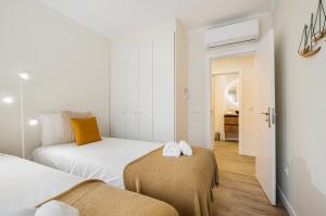 a small bedroom with two beds and a hallway at Monte Estoril Seabreeze in Estoril