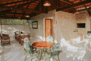 a dining room with a table and chairs in a room at Vila hangloose pôr do sol in Aranaú