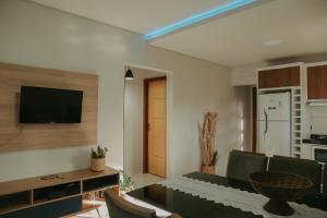 a living room with a couch and a tv on a wall at Vila hangloose pôr do sol in Acaraú