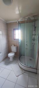 uma casa de banho com um chuveiro e um WC. em Casa Loncura Quintero em Loncura