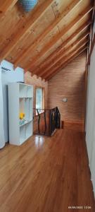 uma sala de estar com tectos em madeira e piso em madeira em Casa Loncura Quintero em Loncura