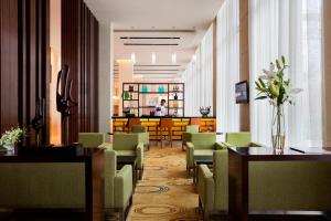 a restaurant with green chairs and tables and a lobby at Fairfield by Marriott Bengaluru Outer Ring Road in Bangalore