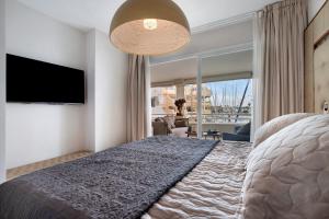 een slaapkamer met een groot bed en een groot raam bij Puerto Marina exclusive apartment in Benalmádena