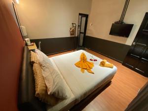 a bedroom with a bed with yellow robes on it at Kavy Boutique Hotel @ KBH in Brinchang