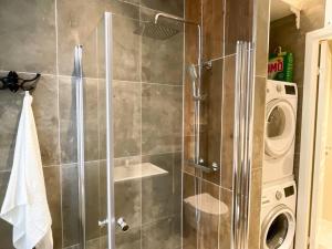 a shower stall in a bathroom with a washing machine at Luxury apartement in Oslo in Oslo