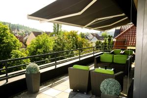 einen Balkon mit Stühlen und Stadtblick in der Unterkunft Hotel Alpha in Stuttgart