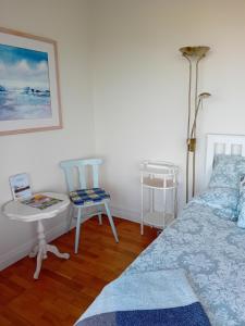 um quarto com uma cama, uma mesa e cadeiras em ATLANTIC VIEW PORTNOO em Clogher