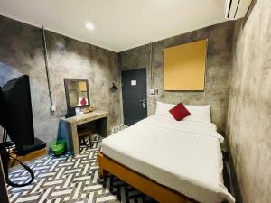 a bedroom with a bed and a tv in it at Na Siam Guesthouse in Phuket Town