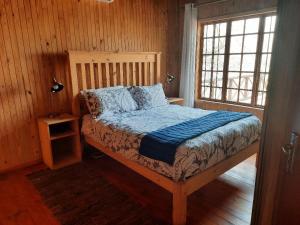 a bedroom with a bed in a wooden room at Habibi Holiday Home in Marloth Park