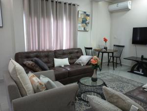 a living room with a brown leather couch and a table at Himma's Apartments 