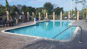 a swimming pool with blue water in a courtyard at Hyatt Place Fort Myers at the Forum in Fort Myers