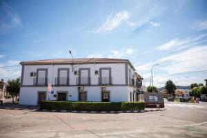 - un bâtiment blanc avec des fenêtres noires dans une rue dans l'établissement Rollo Campillo, à Trujillo