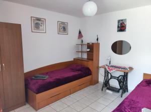 1 dormitorio con cama morada y escritorio en Guest House - Heaven, en Byala