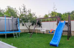 a playground with two swings and a slide at Guest House - Heaven in Byala