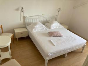 ドゥブロヴニクにあるGuest House Libertas 3の白いベッド(枕2つ付)が備わる客室です。