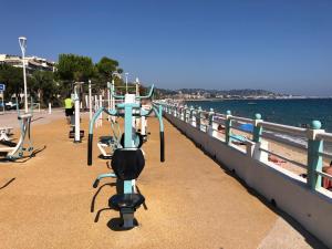 eine Reihe von Trainingsgeräten auf einem Pier neben dem Wasser in der Unterkunft Cannes Terrace Beach Front & Sea view in Cannes