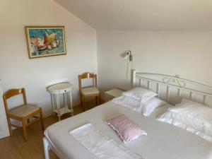 ドゥブロヴニクにあるGuest House Libertas 3のベッドルーム1室(白いベッド1台、椅子2脚付) +4枚の写真