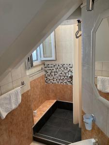 an attic bathroom with a shower and a sink at guesthouse Libertas 3 in Dubrovnik