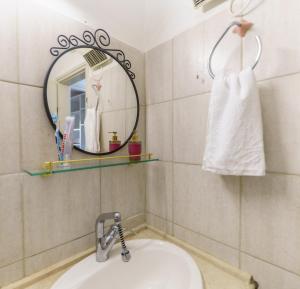 a bathroom with a sink and a mirror at הבית במעלות in Ma'alot Tarshiha