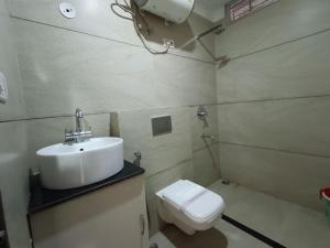 a bathroom with a sink and a toilet at Hotel Satyam in Jaigaon