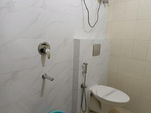 a bathroom with a shower with a toilet and a phone at Hotel Satyam in Jaigaon