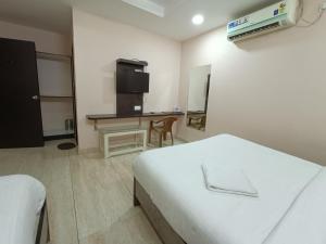 a hotel room with a bed and a desk in it at Hotel Satyam in Jaigaon