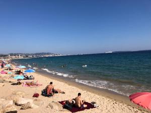 eine Gruppe von Menschen, die am Strand liegen in der Unterkunft Cannes Terrace Beach Front & Sea view in Cannes