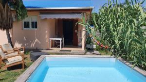 een zwembad voor een huis bij Les Ti Kaz a Papé in Deshaies