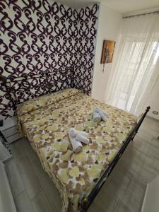 ein Bett mit Hausschuhen in einem Schlafzimmer in der Unterkunft Nunzia's House Materdei in Neapel