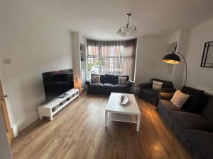 a living room with a couch and a table at Beautiful 4BR Home near Chester Racecourse in Chester