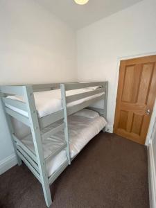 a room with two bunk beds and a door at Beautiful 4BR Home near Chester Racecourse in Chester