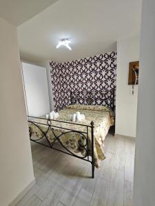 Schlafzimmer mit einem Bett mit gemusterter Wand in der Unterkunft Nunzia's House Materdei in Neapel