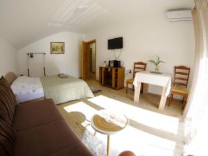 un soggiorno con divano, letto e tavolo di Apartman 'Maslina' a Trebinje