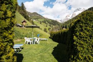 a garden with a table and chairs and an umbrella at Hotel Alcialc in La Valle