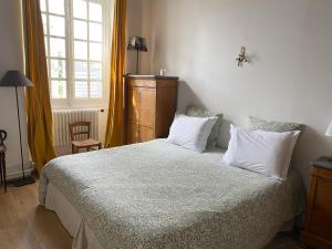 a bedroom with a bed with white pillows and a window at Le Clos Saint Guilhem in Gerzat