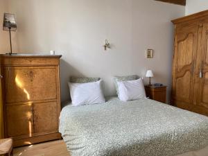 - une chambre avec un lit et une commode en bois dans l'établissement Le Clos Saint Guilhem, à Gerzat