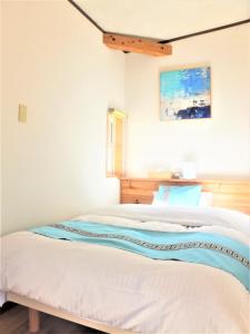 um quarto com uma cama com lençóis azuis e brancos em Me-fi-You Ishigaki Island - Vacation STAY 95379 em Ishigaki