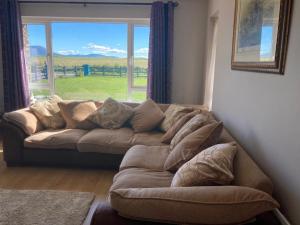 a couch in a living room with a large window at Shanadune in Tralee