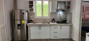 a kitchen with a stainless steel refrigerator and white cabinets at SUITE DENTRO DEL CLUB CASA BLANCA EN SAME in Volcán Chimborazo