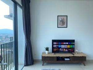 ein Wohnzimmer mit einem TV und einem großen Fenster in der Unterkunft Trefoil @ Studio Comfy~Dhomestay 2 in Shah Alam