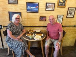 an older man and woman sitting at a table with food at the old house in Kerak