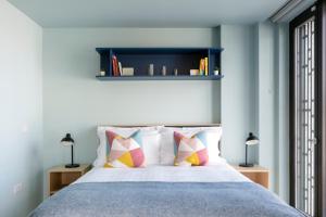 a bedroom with a bed with pillows and a shelf at Coleman Court Summer Accommodation in Cork